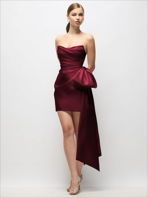 Burgundy strapless satin mini dress with draped pleats and long bow tail