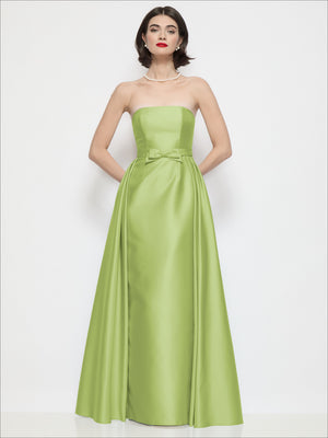 Strapless satin column dress in light chartreuse with waist bow and draped overskirt