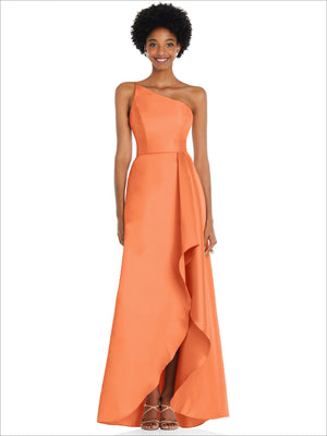 One-shoulder satin gown in peachy orange with draped front slit and pockets.