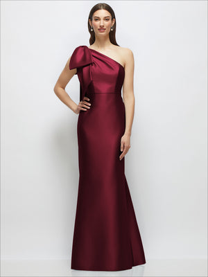 Burgundy one-shoulder satin maxi dress with large bow detail and trumpet skirt.