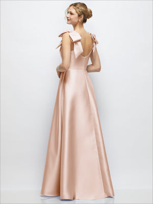 Blush satin ball gown with deep V-neck and tied shoulder bows, full skirt.