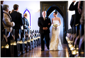 candles lining aisle in church at wedding