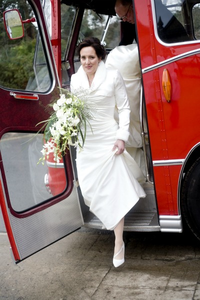 bride stepping out of vintage red bus bride stepping out of vintage red bus