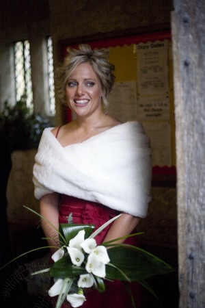 bridesmaid in red dress with fur shrug and white flowers bridesmaid in red dress with fur shrug