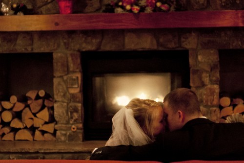 bride and groom in front of log fire bride and groom in front of log fire