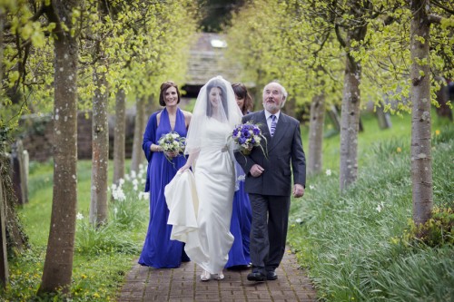 bride walking to church with father of the bride